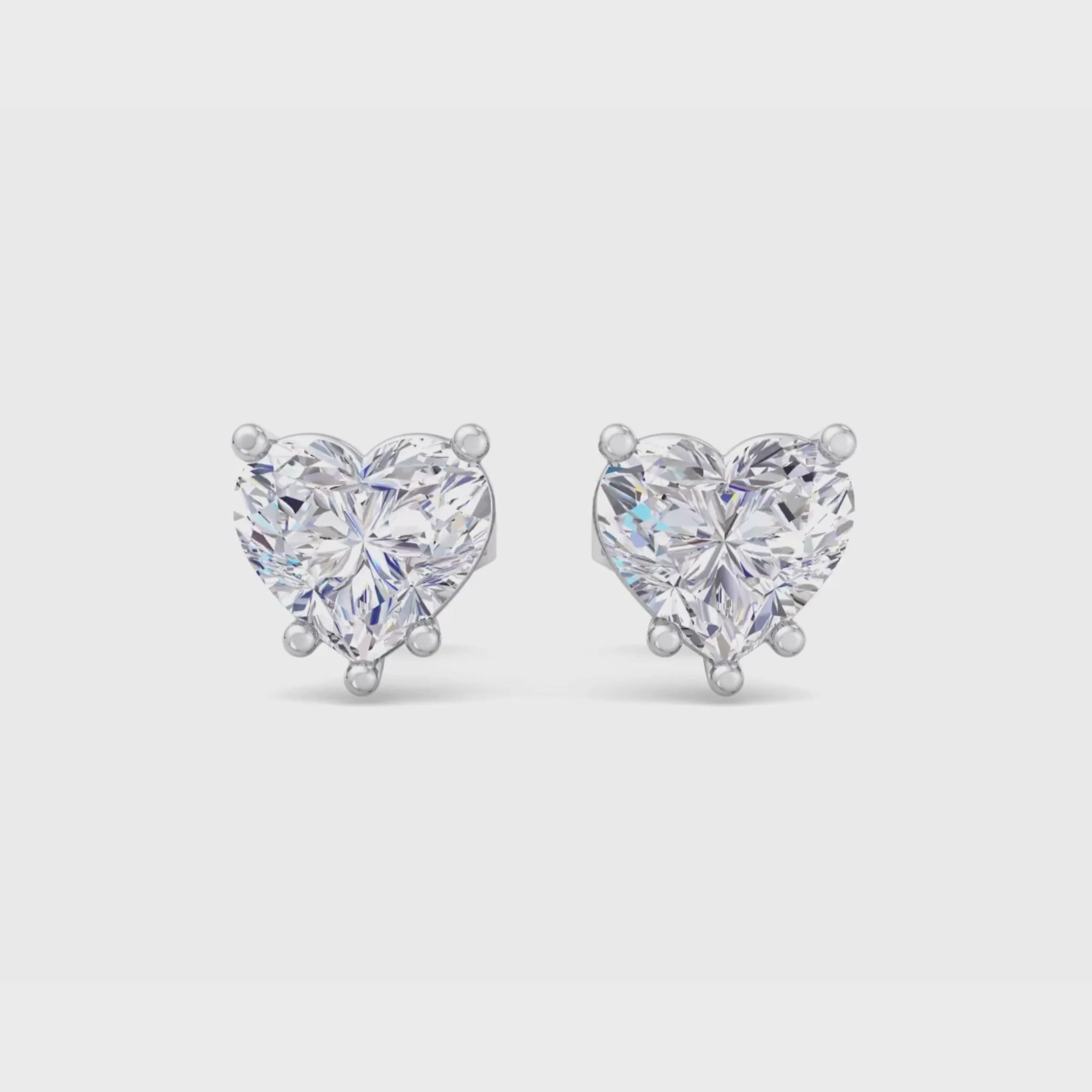 A pair of heart-shaped diamond stud earrings featuring brilliant heart-shaped diamonds with secure backing, perfect for a romantic and elegant look.
