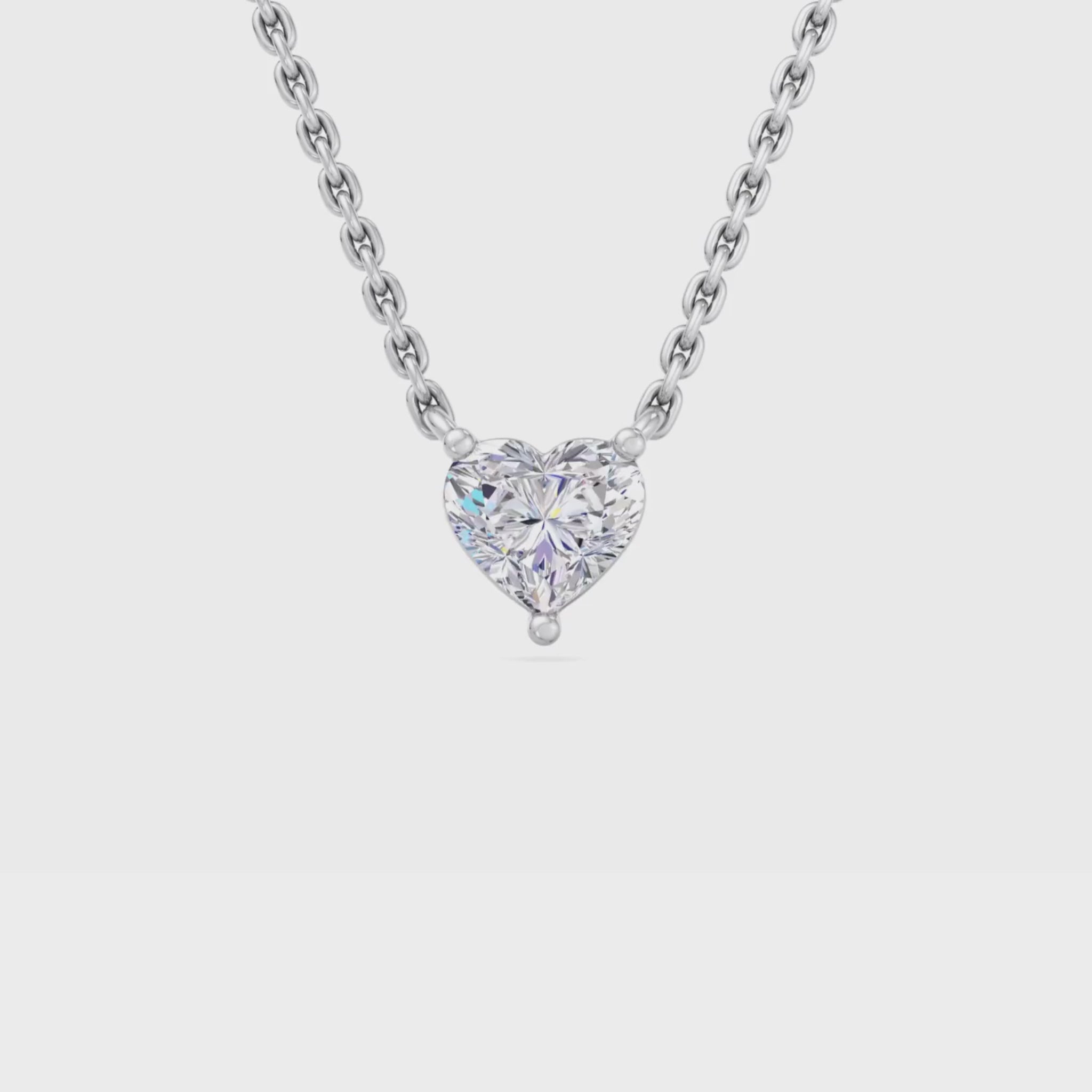 A gold necklace featuring a heart-shaped diamond pendant surrounded by sparkling round-cut diamonds, designed with elegance and charm.