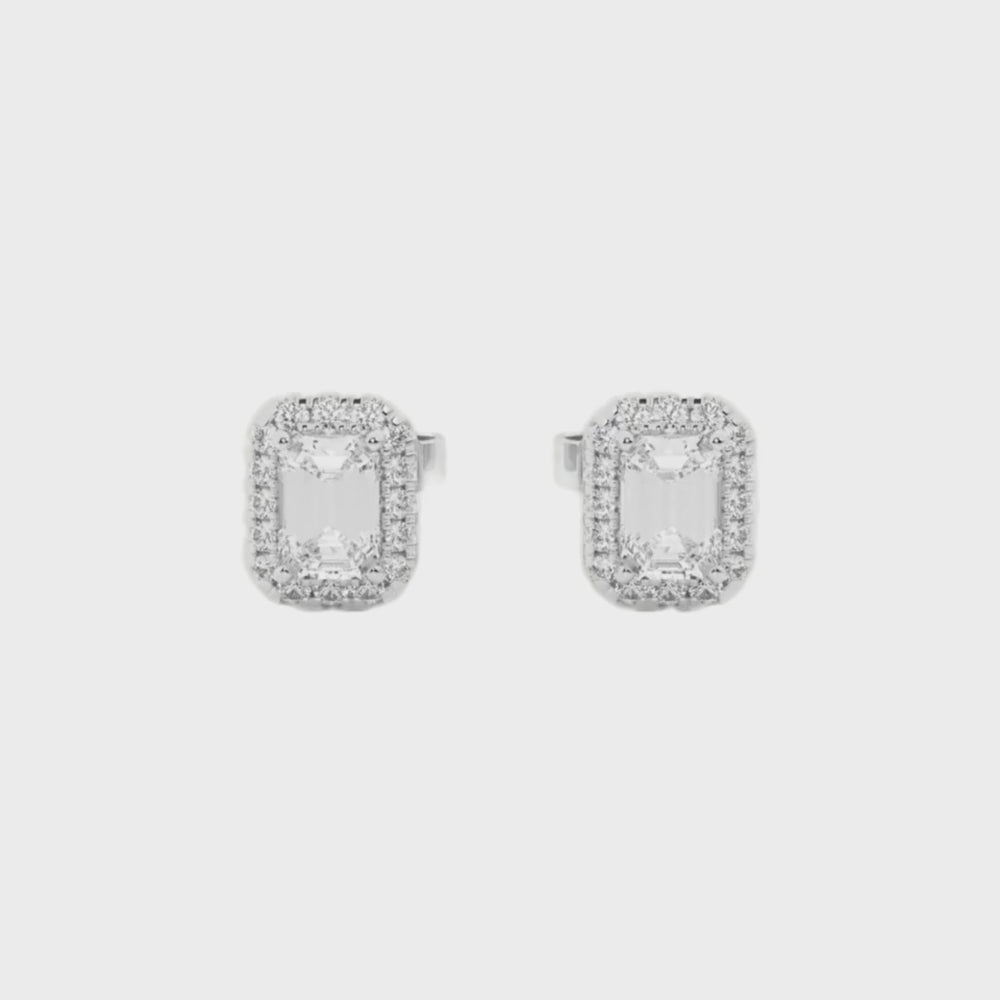 Emerald cut diamond stud earrings with a sparkling halo of smaller diamonds, set in 14k