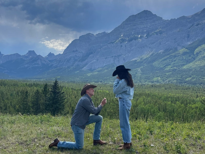 Proposal moment with custom Sakaris Jewelers engagement ring in the mountains