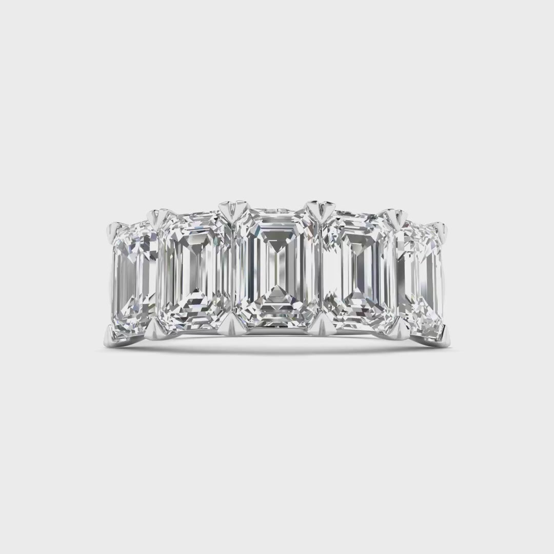 Five stone emerald cut diamond ring featuring 5 carats total weight, with elegant diamonds set in a sleek and timeless band.