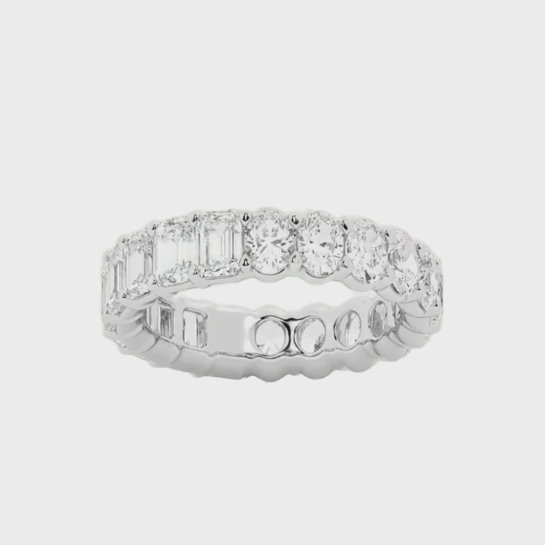 Diamond eternity ring featuring alternating emerald cut and oval cut diamonds, available in 4 carat and 6 carat total weights, set in 14k